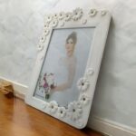 "Decorative floral photo frame with white flowers and red gem design for gifting and home decor."